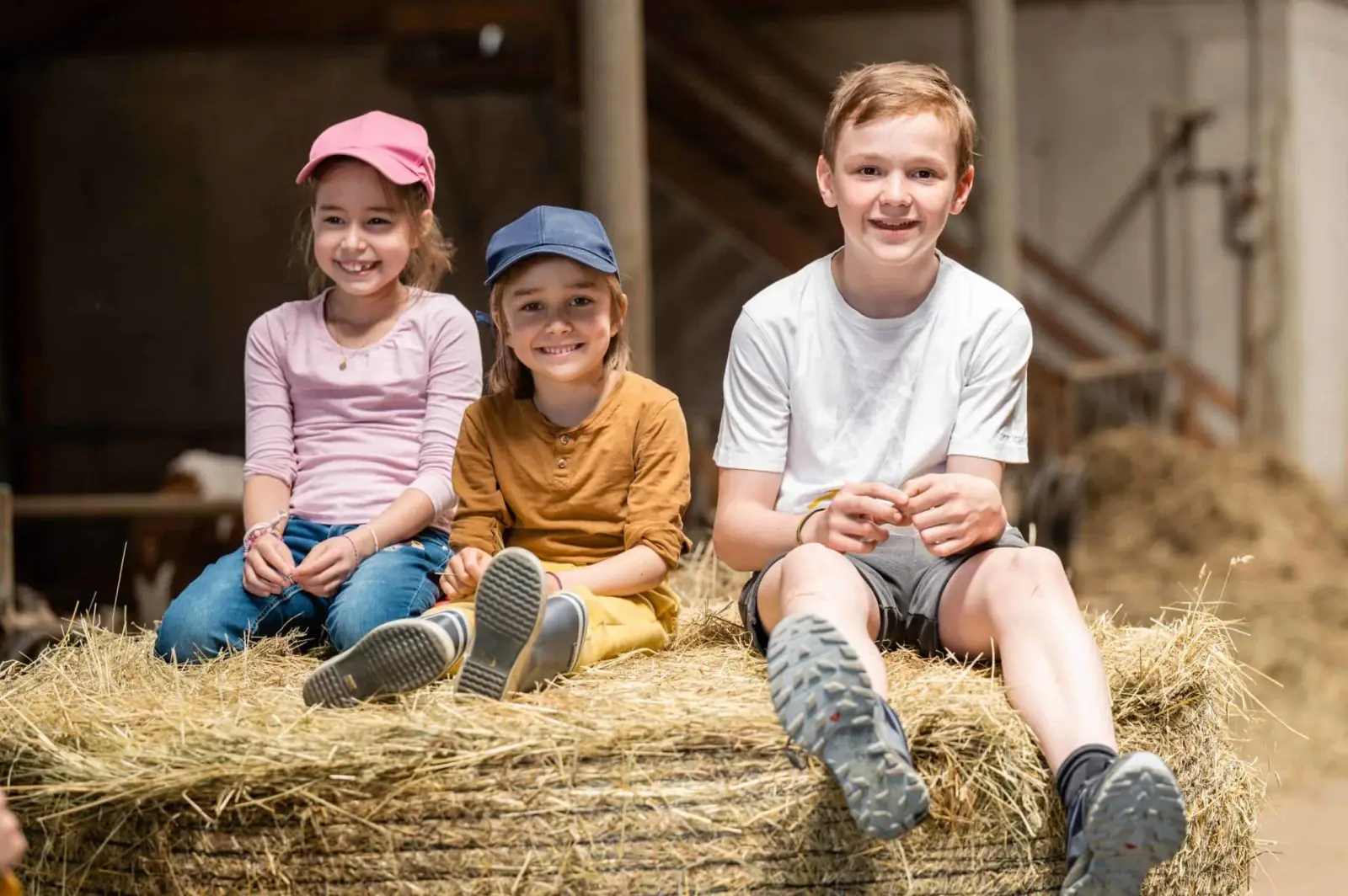Three children sitting on a straw bale